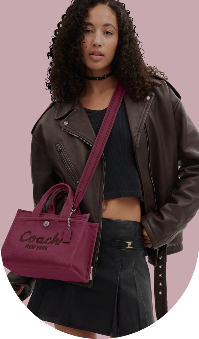 a woman in a leather jacket holding a purse in her hand