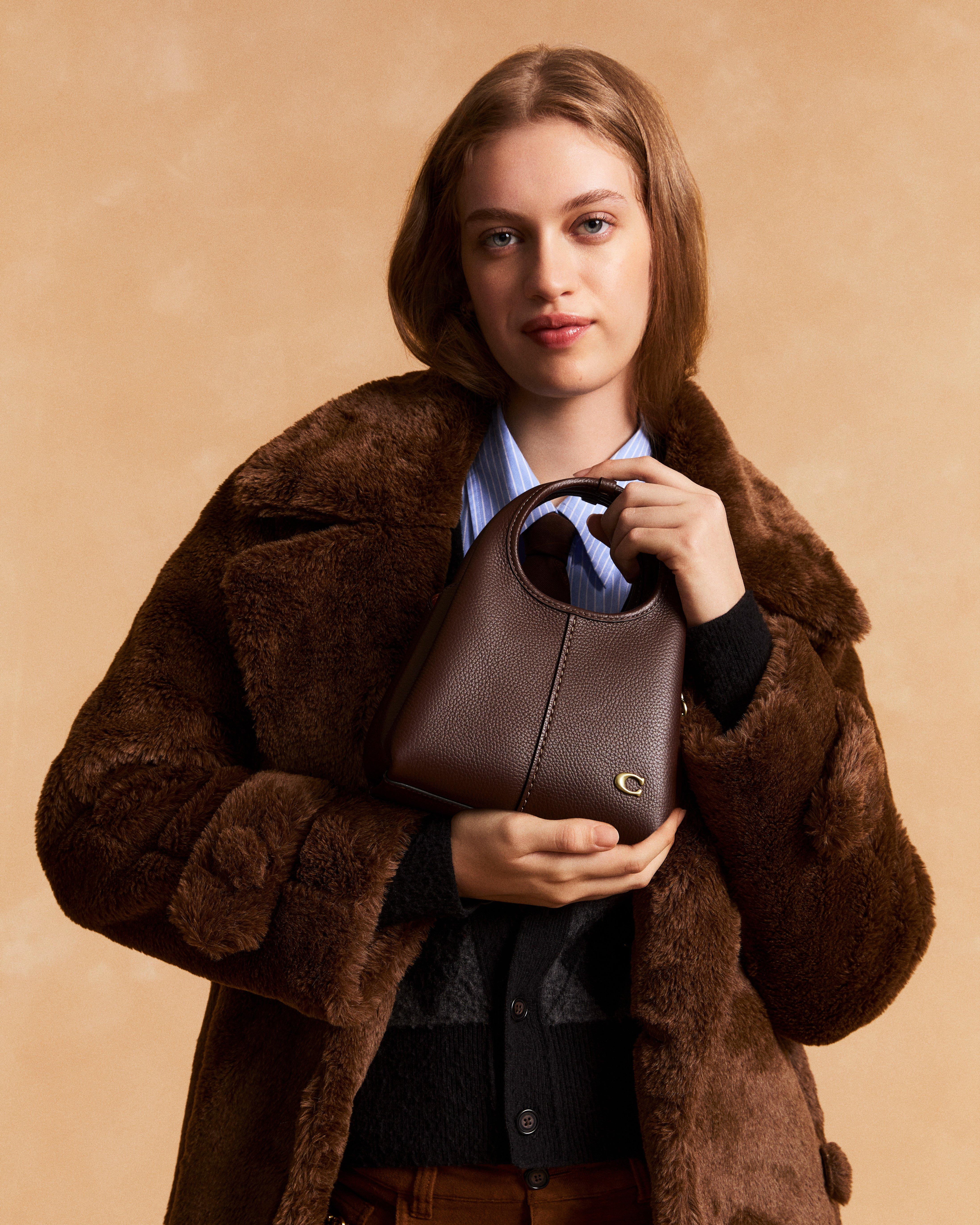 Model standing with shoulder bag