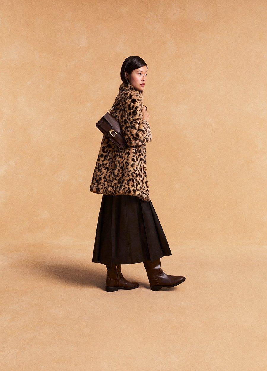Model standing with shoulder bag