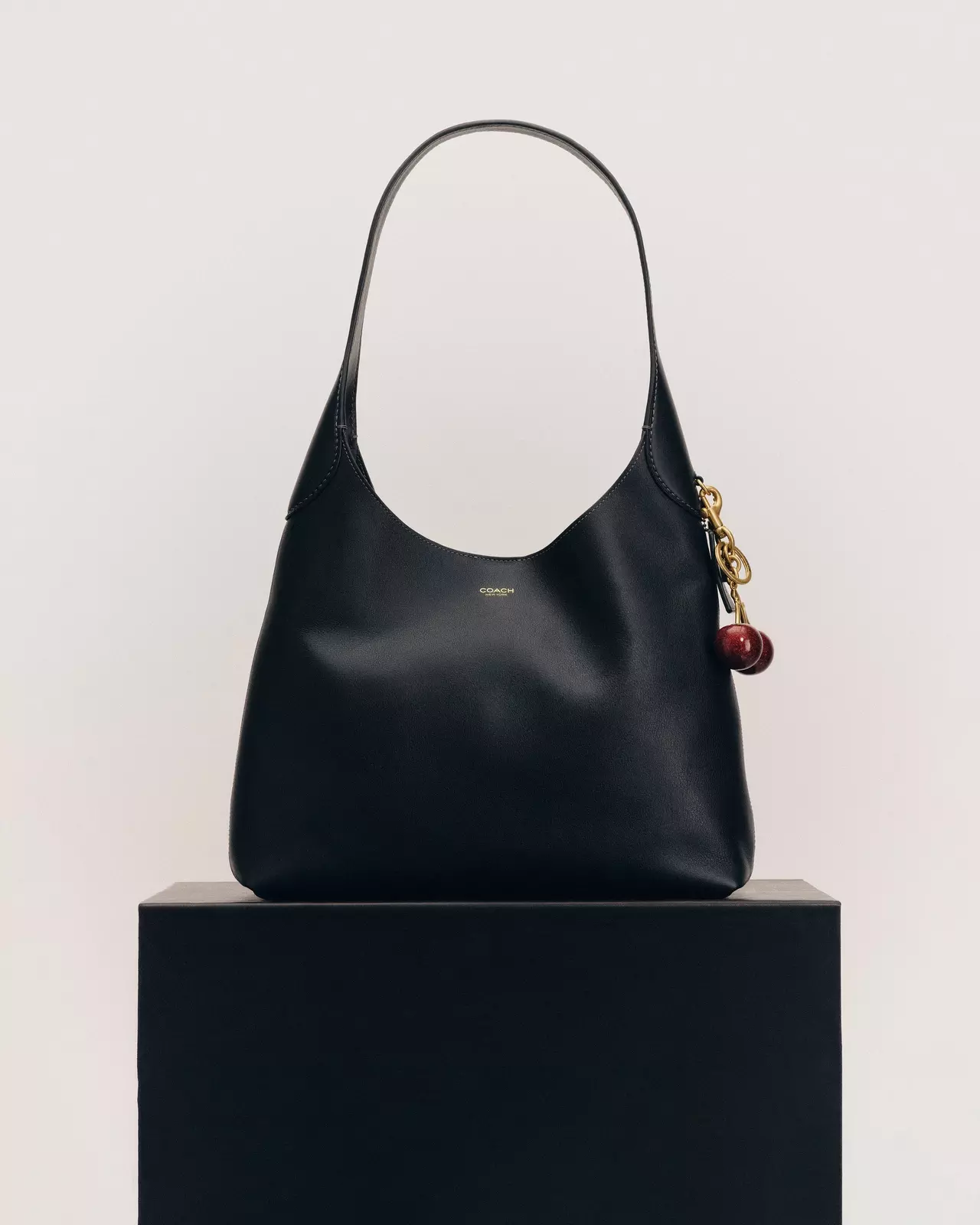 Black hobo shoulder bag on a black plinth