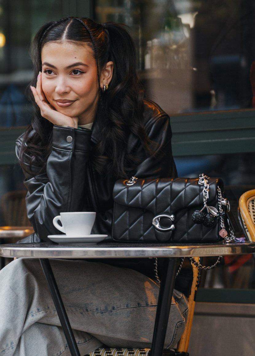 a woman sitting at a table with a cup of coffee
