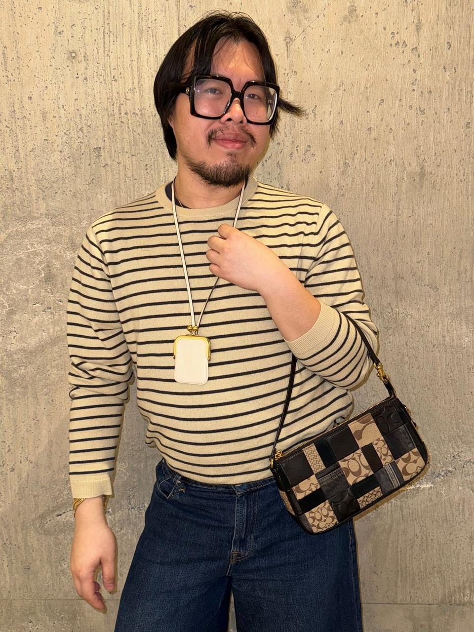 Model standing with shoulder bag