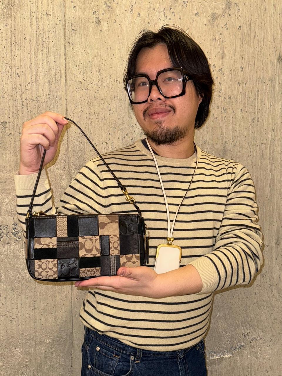 Model standing with shoulder bag
