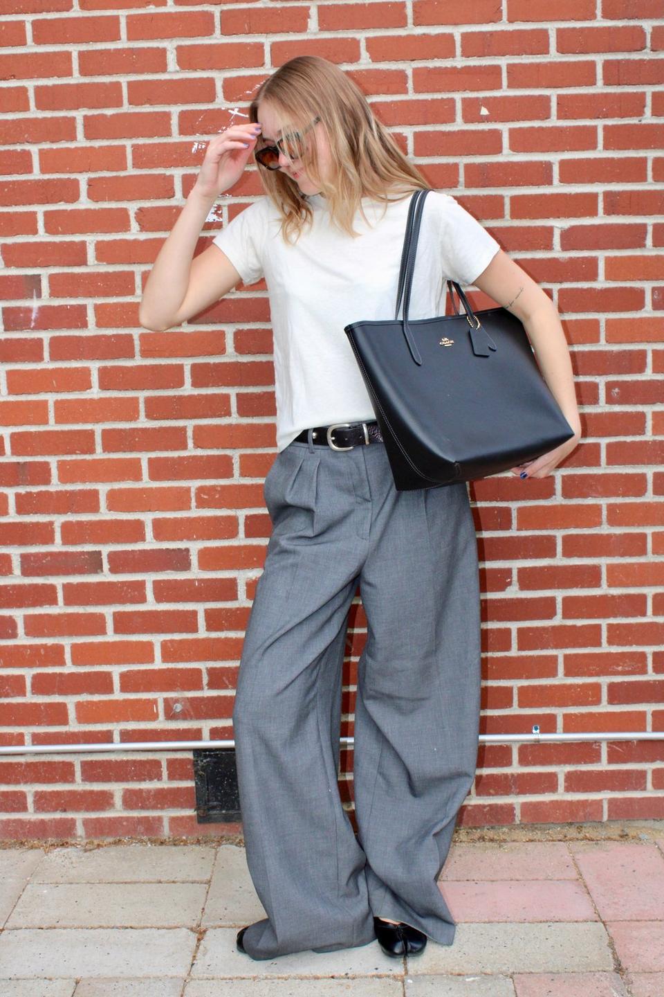 Model standing with shoulder bag
