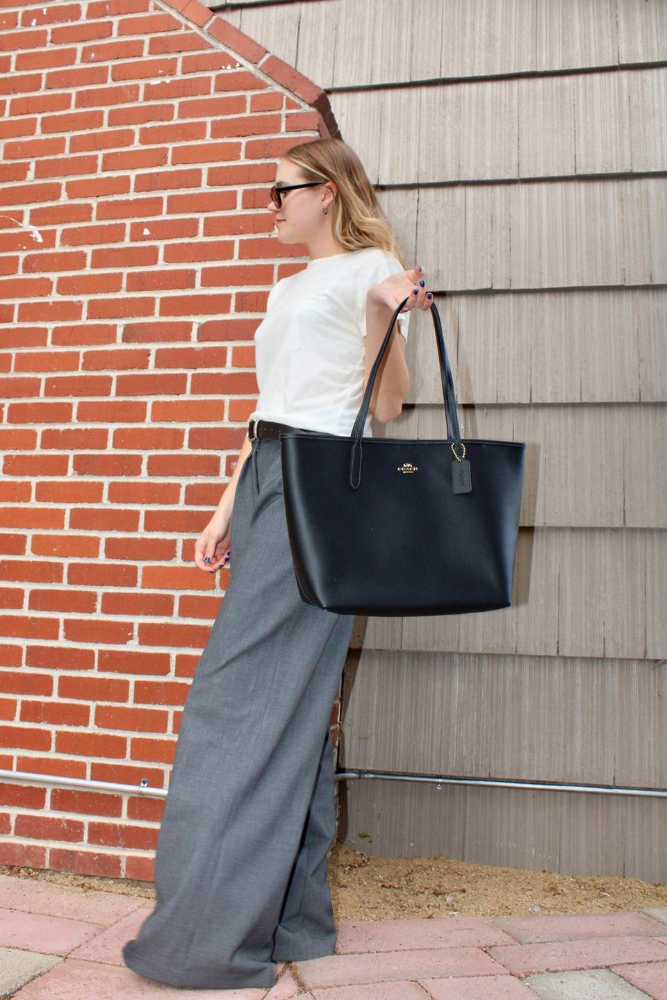 Model standing with shoulder bag
