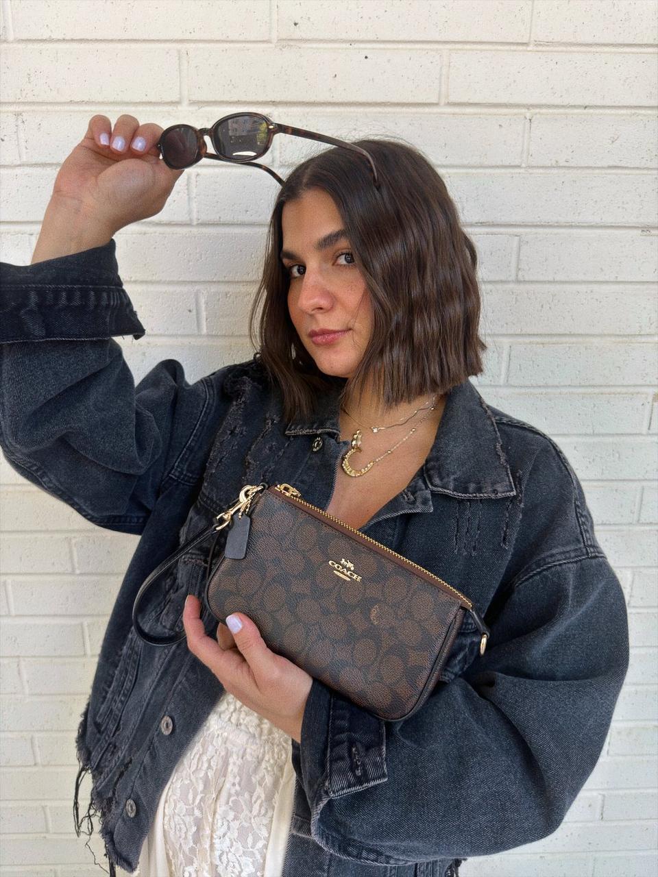 Model carrying a crossbody bag at an outdoor evening gathering