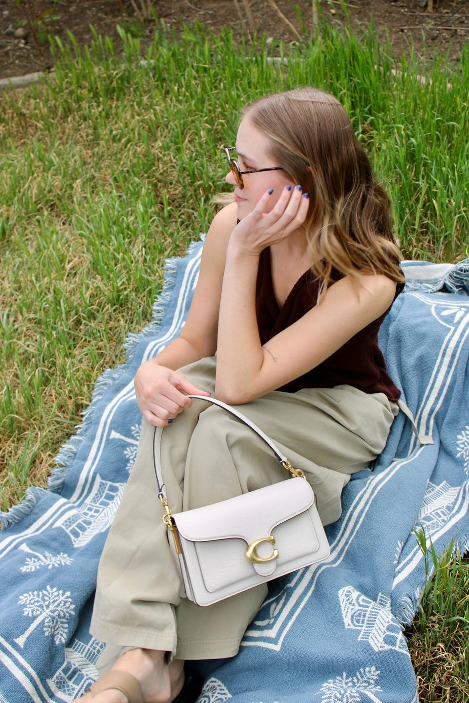 Model standing with shoulder bag