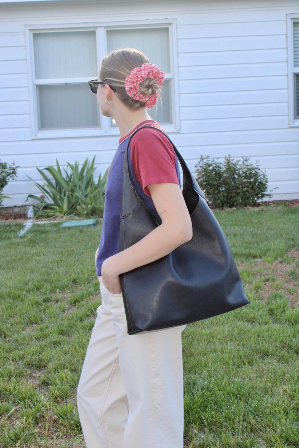 Model standing with shoulder bag