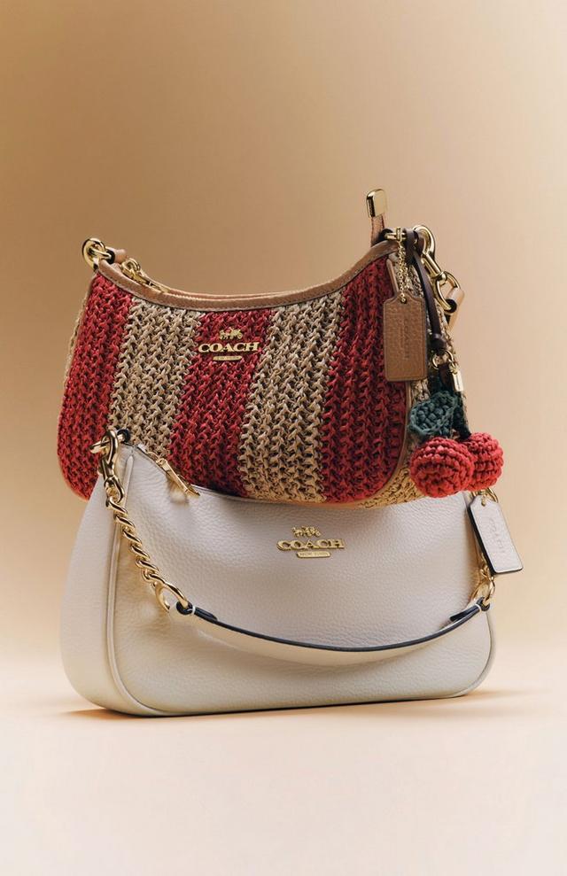 two Coach Teri bags, one crafted of straw with stripes and the other of white pebbled leather
