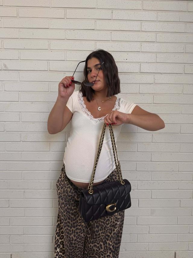 woman holding Coach Tabby Shoulder Bag with pillow quilting in black