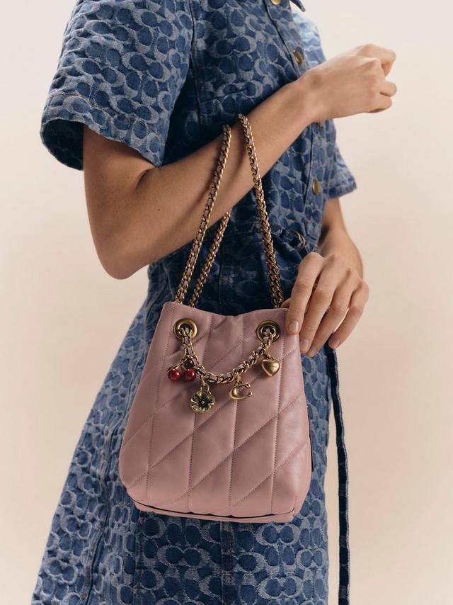 Woman in printed dress wearing a pastel-colored Coach bag