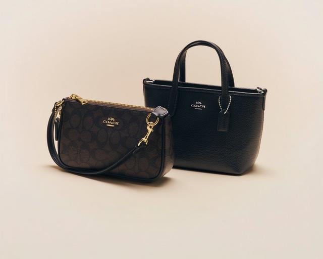 Two black Coach leather handbags with gold hardware, featuring a tote with top handles and a crossbody bag.