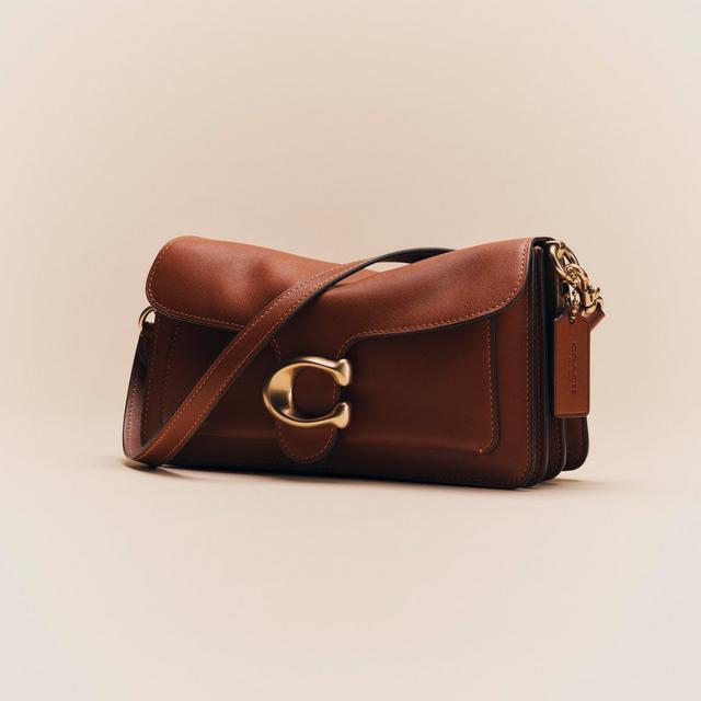 Brown leather Coach shoulder bag with gold-tone C hardware and adjustable strap.
