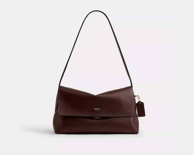 Coach brown leather shoulder bag with flap closure and adjustable strap with luggage tag.