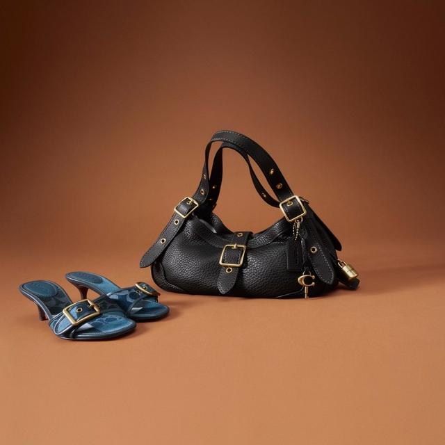 Black leather shoulder bag with gold buckle details and blue leather heeled sandals.