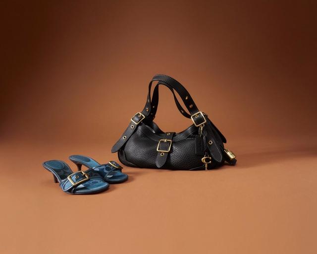 Black leather shoulder bag with gold buckle details and blue leather heeled sandals.