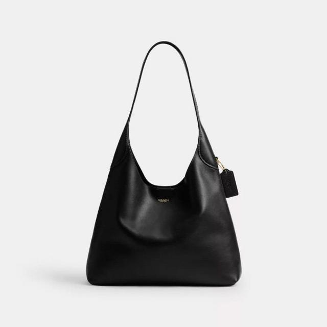 Coach black leather hobo shoulder bag with single strap and brand tag.