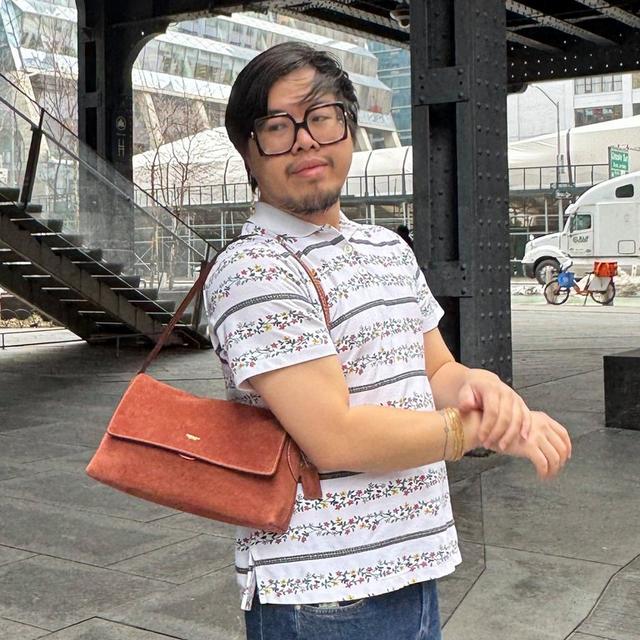 man wearing Coach bag on shoulder