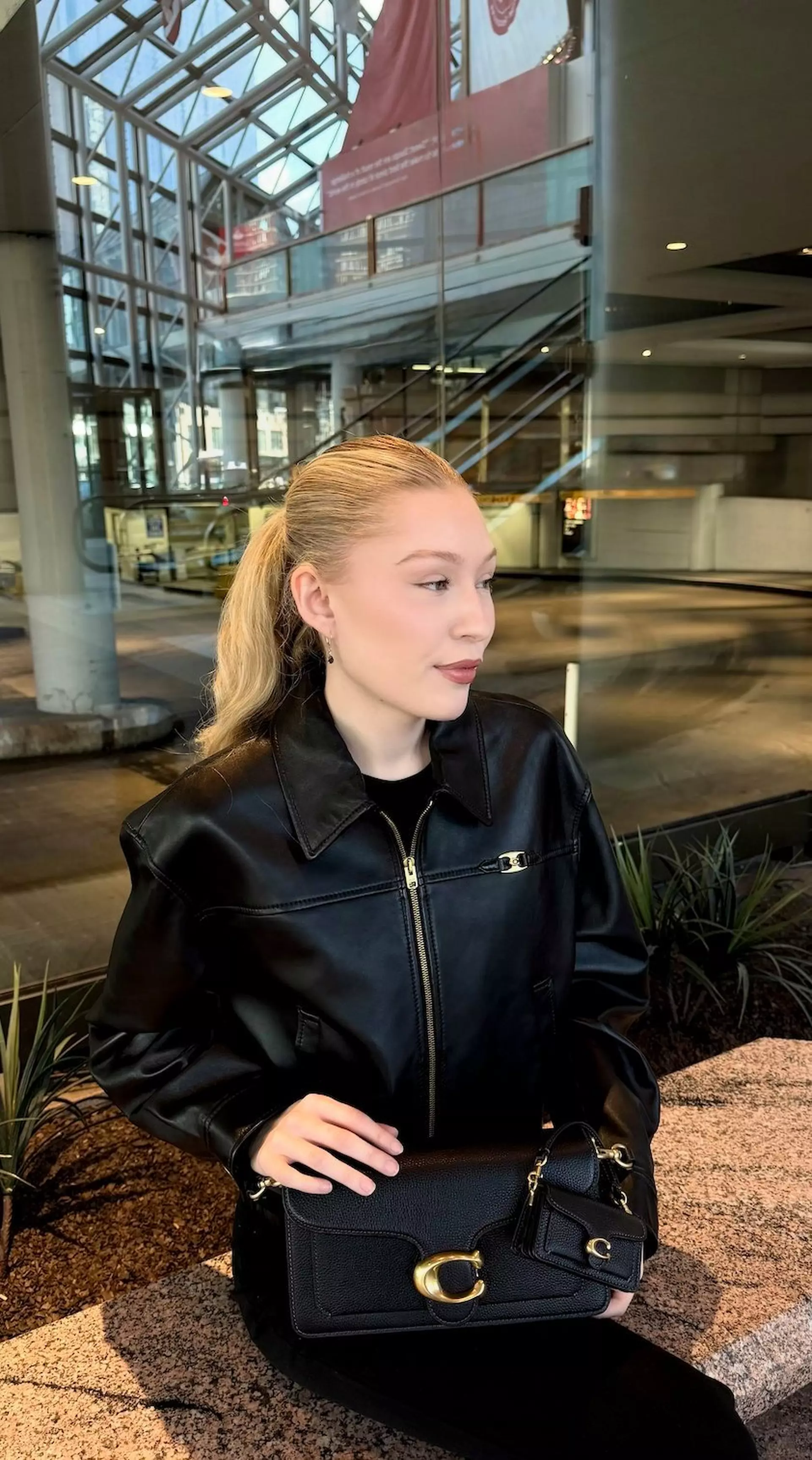 Model styling a neutral handbag