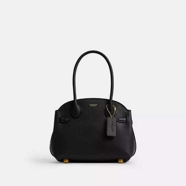 Black Coach leather handbag with top handles, decorative hardware, and protective feet on bottom.