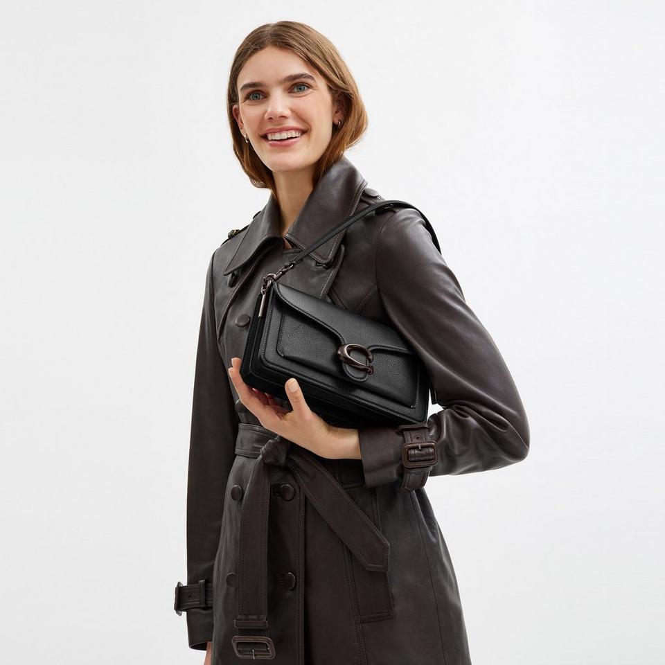 Model standing with shoulder bag
