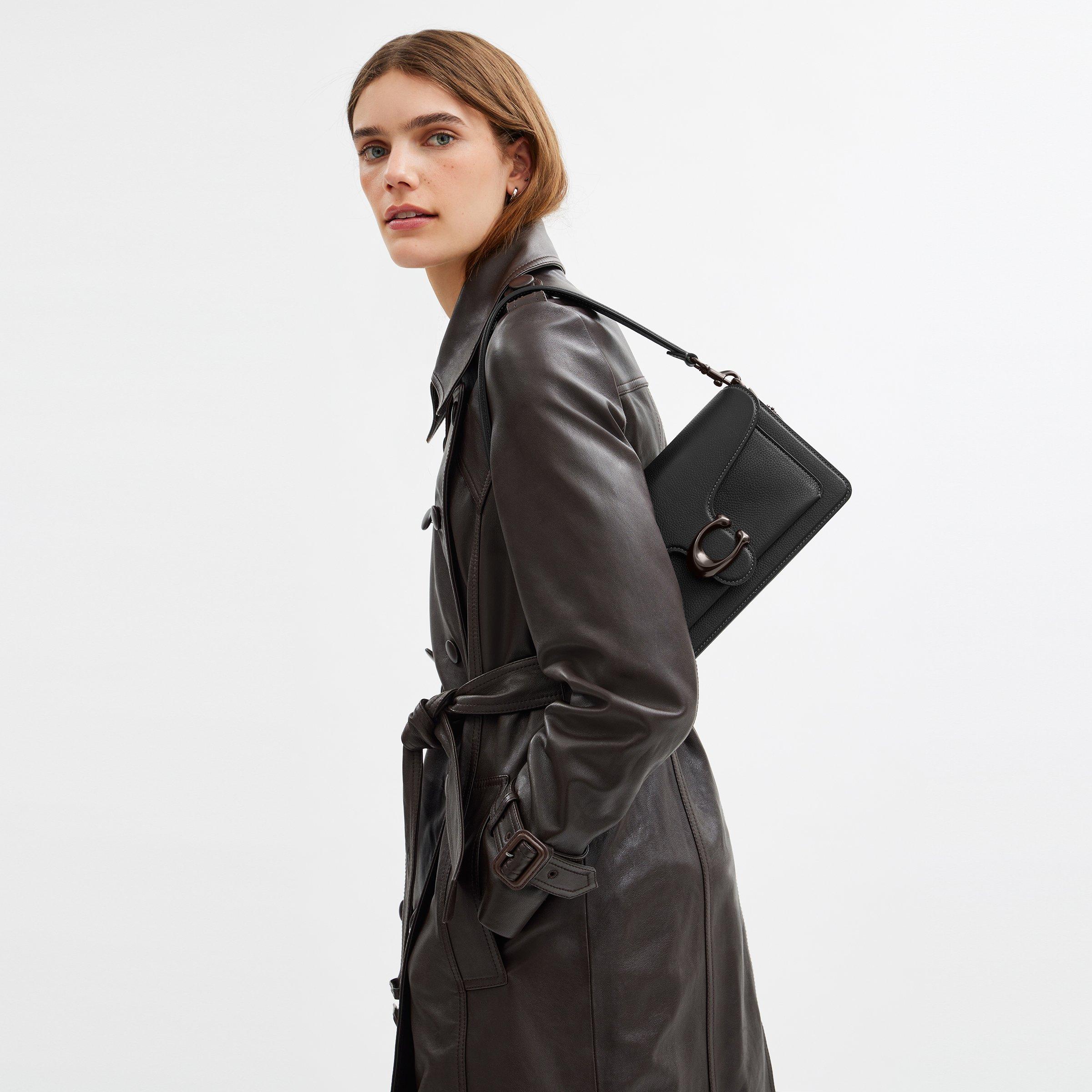 Model standing with shoulder bag