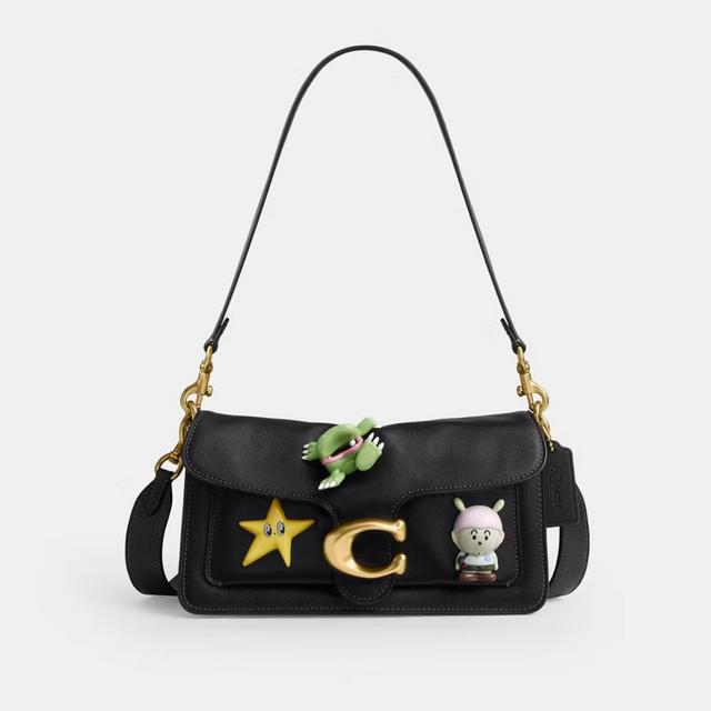 Black leather shoulder bag with gold hardware, featuring playful character charms including a star and hippo.
