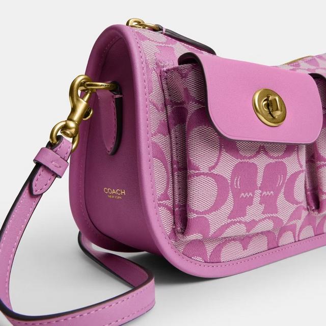 Coach pink crossbody bag with signature monogram pattern and gold-tone hardware.